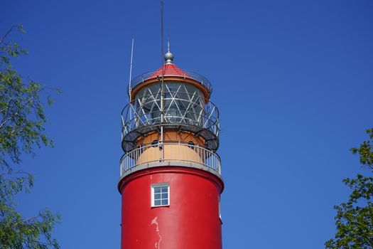 Baltiysk, Russia. Landscape with red lighthouse on blue sky background