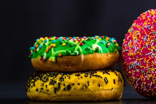 Glazed donuts with sprinkles isolated. Close up of colorful donuts.