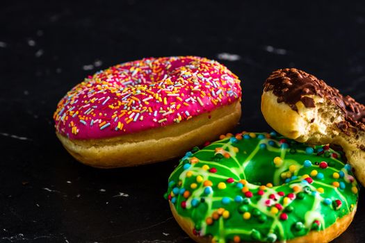 Glazed donuts with sprinkles isolated. Close up of colorful donuts.