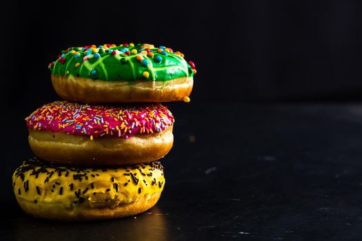 Glazed donuts with sprinkles isolated. Close up of colorful donuts.