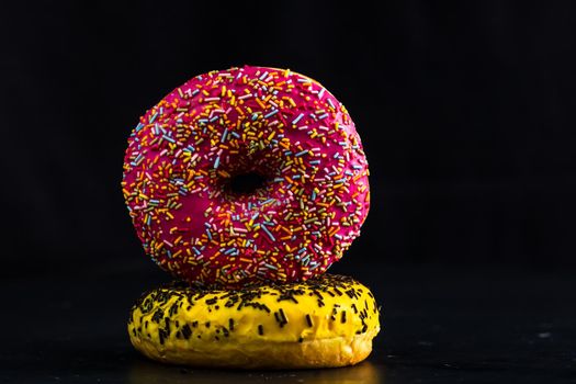 Glazed donuts with sprinkles isolated. Close up of colorful donuts.