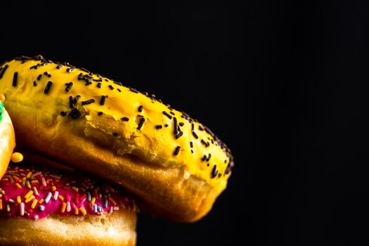 Glazed donuts with sprinkles isolated. Close up of colorful donuts.