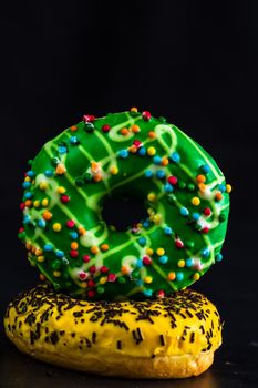 Glazed donuts with sprinkles isolated. Close up of colorful donuts.