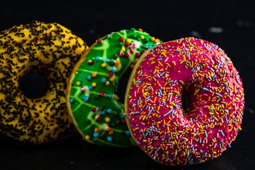 Glazed donuts with sprinkles isolated. Close up of colorful donuts.