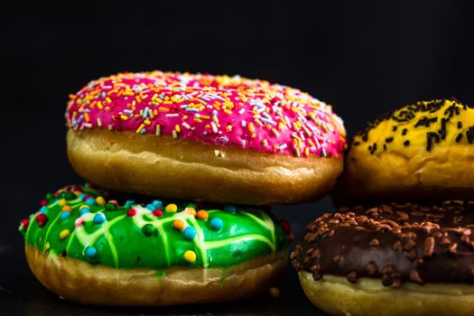 Glazed donuts with sprinkles isolated. Close up of colorful donuts.