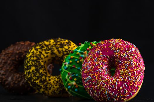 Glazed donuts with sprinkles isolated. Close up of colorful donuts.