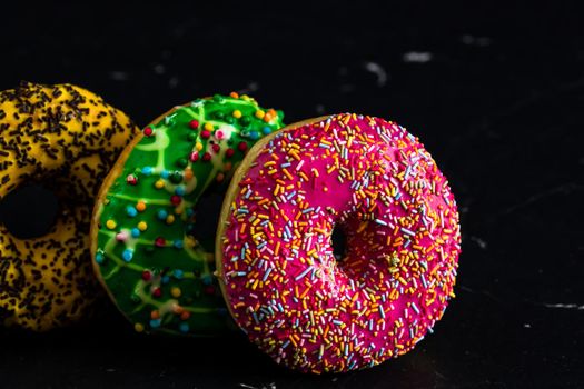 Glazed donuts with sprinkles isolated. Close up of colorful donuts.