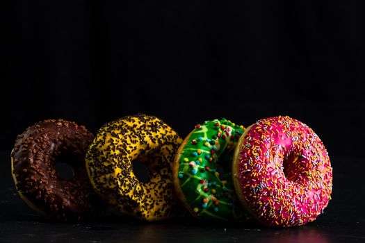 Glazed donuts with sprinkles isolated. Close up of colorful donuts.