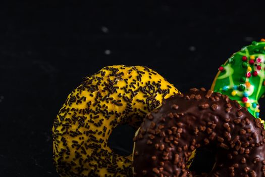 Glazed donuts with sprinkles isolated. Close up of colorful donuts.