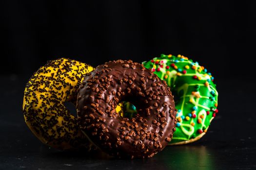 Glazed donuts with sprinkles isolated. Close up of colorful donuts.