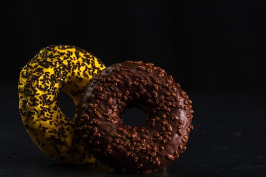 Glazed donuts with sprinkles isolated. Close up of colorful donuts.