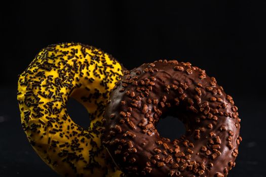 Glazed donuts with sprinkles isolated. Close up of colorful donuts.