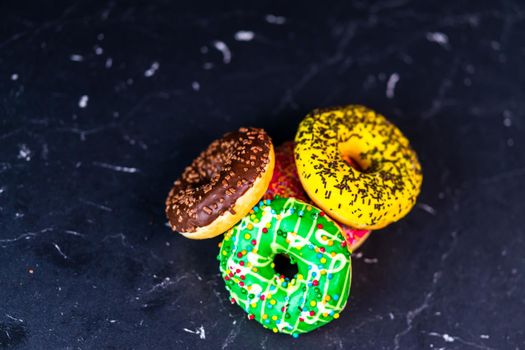 Glazed donuts with sprinkles isolated. Close up of colorful donuts.