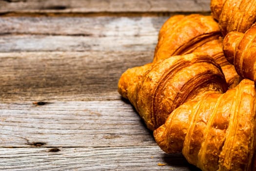 Delicious, fresh croissants isolated on wooden board. French breakfast concept.