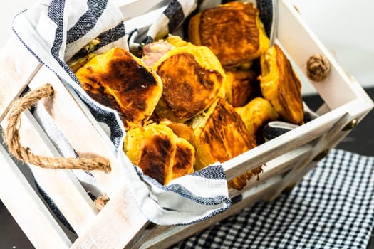 Freshly baked homemade ham and cheese puff pastry in a rustic crate.