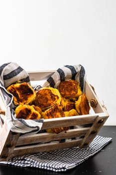 Freshly baked homemade ham and cheese puff pastry in a rustic crate.