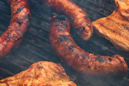 Close up on details of homemade sausages on barbecue grill. Barbecue, grill and food concept.