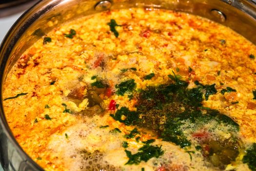 Preparation of soup with chicken and vegetables. Close up of boiling soup.