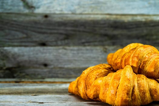 Delicious, fresh croissants isolated on wooden board. French breakfast concept.