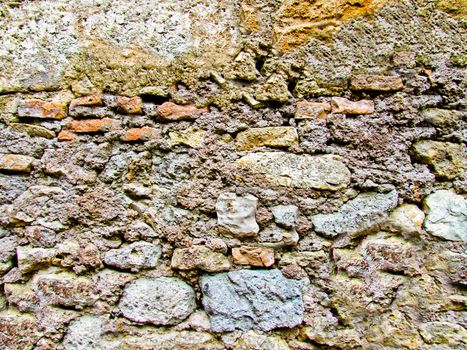 Antique stone wall of gray color with yellow moss and mold.Texture or background