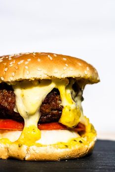 Beef cheeseburger with melting cheese. Tasty homemade cheeseburger isolated on white background.