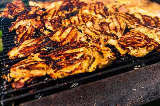 Chicken and pork steak grilled on a charcoal barbeque. Top view of camping tasty barbecue, food concept, food on grill and detail of food on the grill