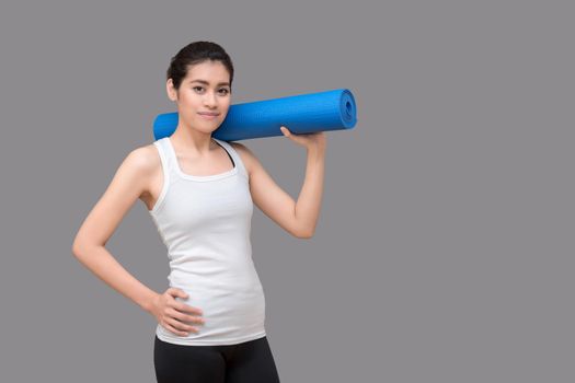 Young asian woman holding her yoga mat at healthy sport gym. Yoga and meditation have good benefits for health. Photo concept for Yoga Sport and Healthy lifestyle