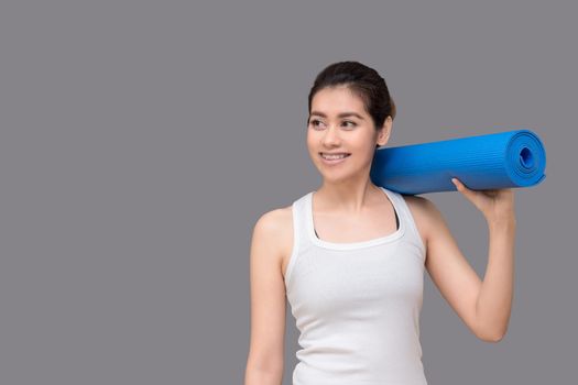 Young asian woman holding her yoga mat at healthy sport gym. Yoga and meditation have good benefits for health. Photo concept for Yoga Sport and Healthy lifestyle