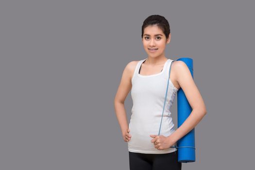 Young asian woman holding her yoga mat at healthy sport gym. Yoga and meditation have good benefits for health. Photo concept for Yoga Sport and Healthy lifestyle