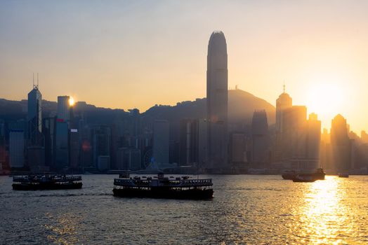 Hong kong traditional wooden chinese boat for tourist service in victoria harbor at sunset view from Kowloon side at Hong Kong.