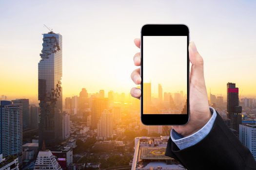 Business woman showing smartphone with transparent screen and copy space on smart city in background. Elegant design for business and smart city concept.