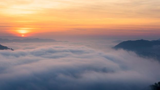 Panorama view of amazing mist moving over the nature mountains during sunrise at mountains area in Thailand.