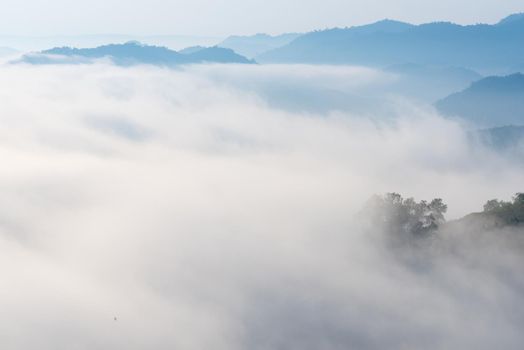 View of amazing mist moving over the nature mountains during sunrise at mountains area in Thailand.