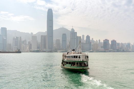 Hong kong traditional wooden chinese boat for tourist service in victoria harbor at sunset view from Kowloon side at Hong Kong.