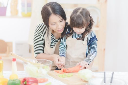 Happy loving family asian mother and her daughter prepare healthy food salad in kitchen room.Photo design for family, kids and happy people concept