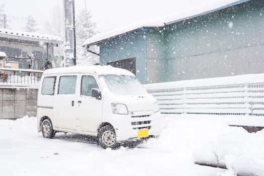 Fresh white snow falling at public park cover road and car in winter season at Kawaguchiko,Japan.