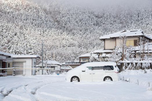 Fresh white snow falling at public park cover road and car in winter season at Kawaguchiko,Japan.