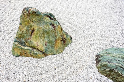 Japanese zen garden meditation stone in lines sand for relaxation balance and harmony spirituality or wellness in Kyoto,Japan.