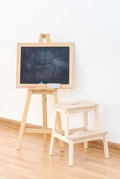 Wooden blank blackboard inside the room for kids playing and education teaching by parent for modern happy family activity.