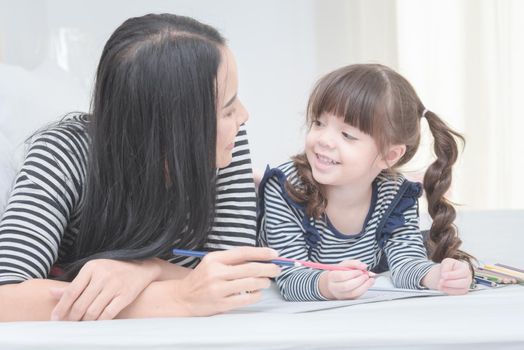 Happy loving family mother and her daughter child girl play in children room. Funny mom and lovely child having fun together.Photo design for family, children and happy people concept