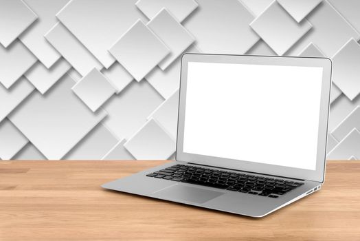 Smart modern laptop with blank white screen on wooden table and modern geometry wall in background.Elegant Design with copy space for mock up product or graphic display.