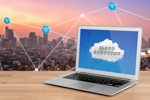 smart modern laptop showing technology for cloud computing on screen with Smart city with wifi connection in background.Photo design for smart city and smart technology internet of things concept