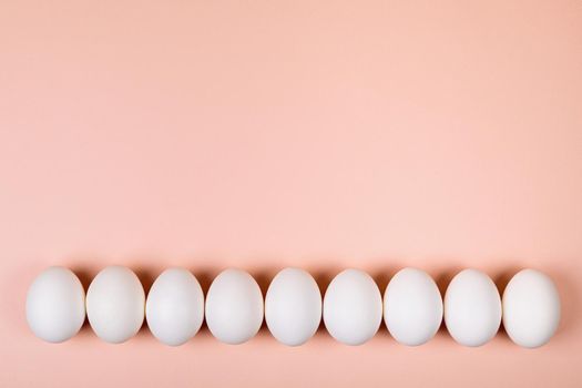 Easter eggs white on a pink background with place for text. Various compositions in a row, top, side, bottom.