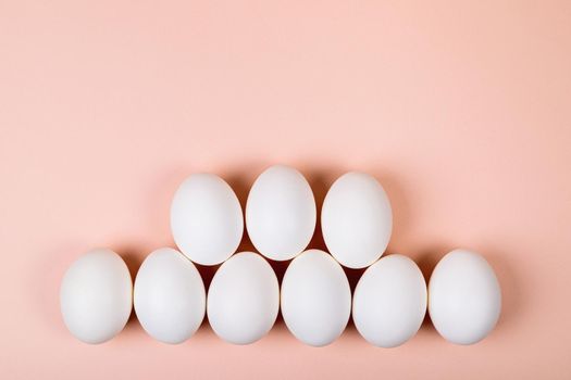 Easter eggs white on a pink background with place for text. Various compositions in a row, top, side, bottom.
