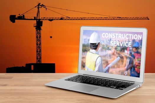 Laptop showing construction service concept for engineer with foreman worker checking construction site for new Infrastructure construction project