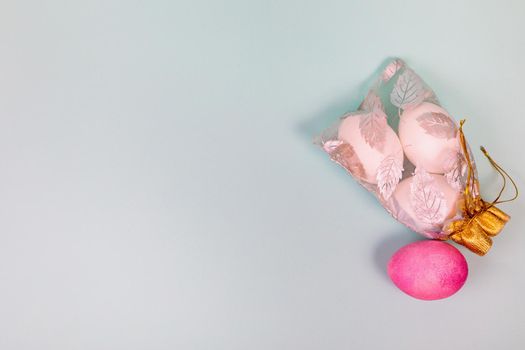 Easter. White eggs with a red egg in a bag on a uniform blue background. Place for text.