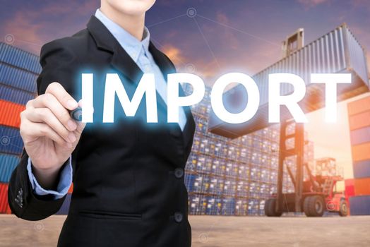 Smart business woman is writing Import word with forklift lifting cargo container and cargo containers stack in background for global transportation import,export and logistic business concept