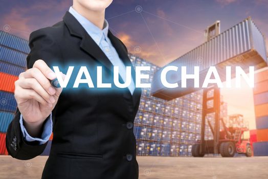 Smart business woman is writing value chain word with forklift lifting cargo container and cargo containers stack in background for global transportation import,export and logistic business concept