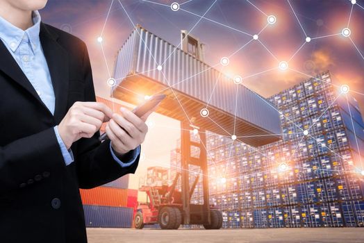 Smart Business woman use smartphone and internet of things technology for Global business connection with global customer for worldwide container cargo shipping.Logistic Import Export business concept