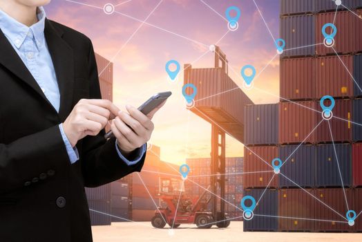 Smart Business woman use smartphone and internet of things technology for Global business connection with global customer for worldwide container cargo shipping.Logistic Import Export business concept